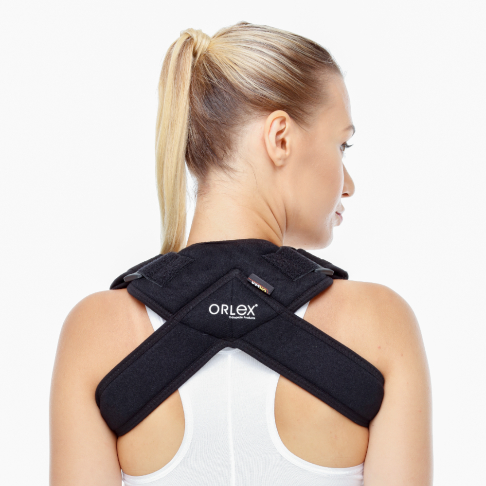 orx-o303-dampigo-orlex-klavikula-bandaji-siyah-1 Siyah renkte, sırt desteği olan bir klavikula (köprücük kemiği) bandajı takan bir kadın." veya "Omurga ve omuz desteği sağlayan ortopedik korse.